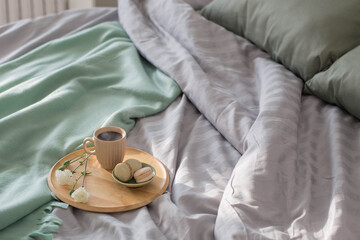 Poster - cup of coffee on wooden tray on bed in sunlight