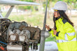 © reewungjunerr - Technician fixing the engine of the airplane,Female aerospace engineering checking aircraft engines,Asian mechanic maintenance inspects plane engine