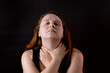 © Юля Бурмистрова - Exhausted young woman choking throat. Female portrait isolated on black. Unhappy girl concerned with troubles. Suffocation, suicide, lay hands on yourself. Facial expression and gesticulation concept.
