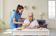 © Studio Romantic - Friendly smiling nurse caregiver in geriatric clinic or retirement home helps senior man with Alzheimer's disease. Happy old man plays puzzles while sitting at table in cozy interior. Dementia concept