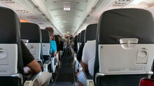 Back Of Airplane Interior. Passenger Perspective In Plane Corridor