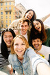 © Xavier Lorenzo - Vertical photo of young group of happy people taking selfie enjoying time together. Multiracial student friends laughing at mobile phone camera photo.