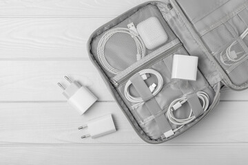 Puts wires of tablet advanced electronic equipment, phone charger in a convenient storage bag. Preparing for a business trip or vacation. Packing method for technological tools.