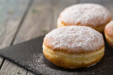 Fototapeta  - Ruddy delicious donuts berliners on a stone board