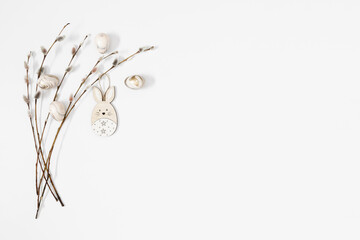 Wall Mural - Easter trendy composition. willow plant branches, easter eggs and bunny on white background. Minimal concept Easter. Flat lay, top view, copy space
