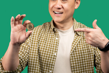Poster - Digital cryptocurrency, trading on stocks and markets concept. Korean middle aged businessman pointing at golden bitcoin