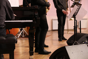 Wall Mural - A group of musicians playing piano and brass instruments jazz stand on the stage