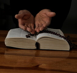 praying to God with hand on the bible on black background stock photo	