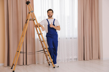 Poster - Worker in uniform showing thumbs up near window curtains indoors