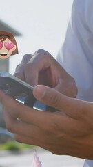 Poster - Animation of emoticons over hands of biracial man using smartphone in city