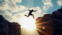 Man Jumping Over Cliff. Energetic Man. Strong Man Succeeds In Life. 