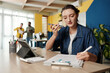 © DragonImages - Businesswoman listening to voice message from colleague when checking report