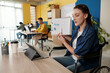 © DragonImages - Young businesswoman pointing at chart on clipborad when having online meeting with business partner