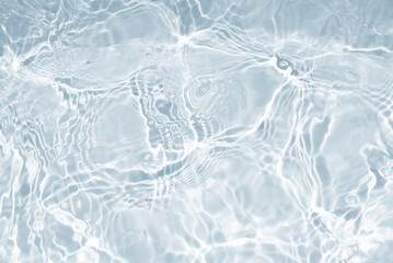 Water waves surface hits the sunlight. Close up swimming pool water background. Transparent water surface.