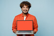 © ViDi Studio - Young happy IT Indian man wear orange red shirt white t-shirt hold use work on laptop pc computer with blank screen workspace area isolated on plain pastel light blue cyan background studio portrait.