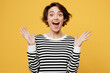 Young european surprised shocked amazed woman wear casual striped black and white shirt look camera spread hands say wow isolated on plain yellow color background studio portrait. Lifestyle concept.