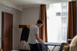 © Astrakan Images - Man ironing clothes in hotel room