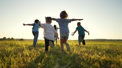 happy holiday in nature. family and friend run together on green grass in summer.active children wal