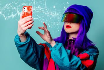 Poster - Stylish girl in cyber punk glasses and 80s tracksuit using mobile phone on blue background