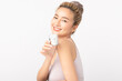 © Shutter B - Happy beautiful young asian woman holding cosmetic cream blank bottle, Fashion model, Health wellness, Beautiful girl skin care and facial treatment. Isolated on white background.