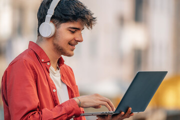 Poster - young male with headphones and laptop in the street