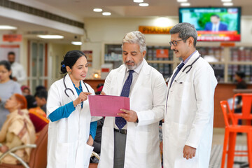 Wall Mural - Indian doctors team watching report and discussing at hospital.