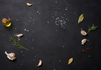 Wall Mural - Scattered coarse white salt, peppercorns and rosemary sprigs on a black table, ingredients for cooking fish and meat