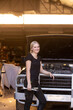 © Austockphoto - Young female aussie mechanic holding tools and leaning on a car in need of repair in workshop garage