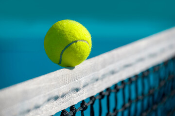 Wall Mural - close-up of a tennis ball balancing on the edge of a tennis net