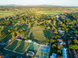 Sports ground, tennis club and football oval beside golf course at edge of town of Singleton