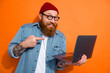 © deagreez - Photo of funky young guy holding netbook pointing finger demonstrate website discounts sale isolated on shine color background