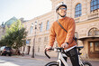 © muse studio - A male cyclist in a helmet is a teenager freelancer going to the office for work Monday on a bicycle eco transport in the city.