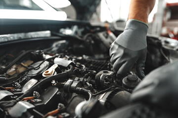 Wall Mural - Close up of mechanic's hands repairing car engine in car service