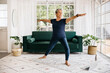 © (JLco) Julia Amaral - Warrior pose for seniors: Mature woman shows her strength and flexibility as she practices this yoga pose at home