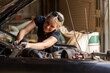 © Austockphoto - young australian tradesperson mechanic fixing car engine in automotive repair garage