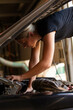 © Austockphoto - young female tradesperson mechanic fixing car engine in automotive repair garage