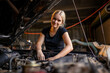 © Austockphoto - young female australian tradesperson mechanic working on car engine in auto repair garage