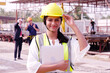 Smiling construction engineer in safety helmet working at construction site.