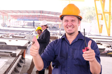 Smiling construction engineer in safety helmet working at construction site.