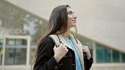 Wall Mural - Young beautiful hispanic woman student smiling confident standing at street