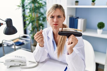 Sticker - Beautiful dentist woman comparing teeth whitening skeptic and nervous, frowning upset because of problem. negative person.