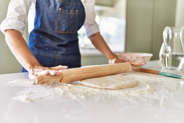 Poster - Young blonde woman kneading pizza dough at kitchen