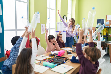 Poster - Woman and group of kids having recycling lesson holding empty bottle at classroom