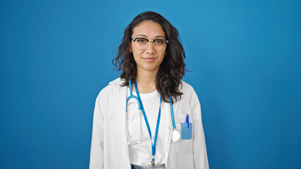 Sticker - Young beautiful hispanic woman doctor smiling confident standing over isolated blue wall background