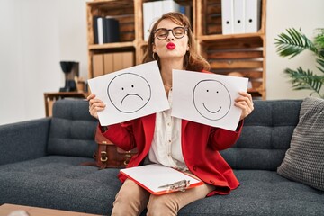 Poster - Young beautiful woman working on depression holding sad to happy emotion paper looking at the camera blowing a kiss being lovely and sexy. love expression.