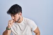 © Krakenimages.com - Hispanic man with beard standing over white background feeling unwell and coughing as symptom for cold or bronchitis. health care concept.
