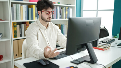 Poster - Young hispanic man student doing yoga exercise at library university