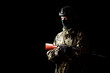 © Arsentyev Vladimir - An armed soldier in military uniform holds a rifle in his hands on a black background, studio