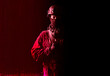 © Arsentyev Vladimir - An armed soldier in military uniform holds a rifle in his hands on a black and red background, studio