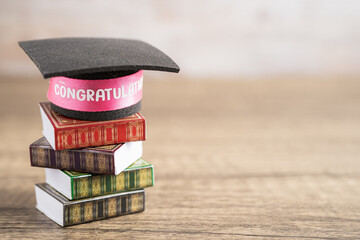 Wall Mural - Graduation hat on book with copy space, learning university education concept.